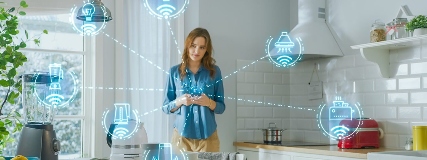 A woman at home using a device which is connected to other appliances and machines around her